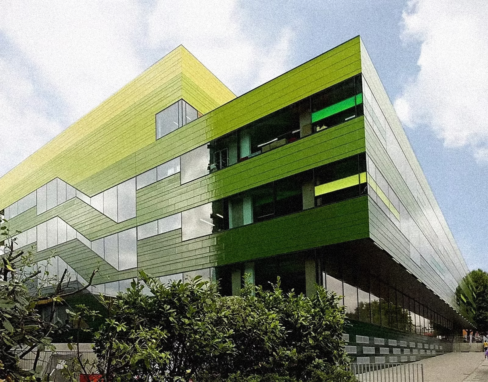 Modern green building with geometric design against a blue sky